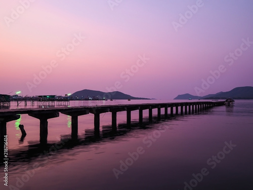Local pier at sunrise or sunset background in Thailand. Wooden bridge at twilight purple sky.