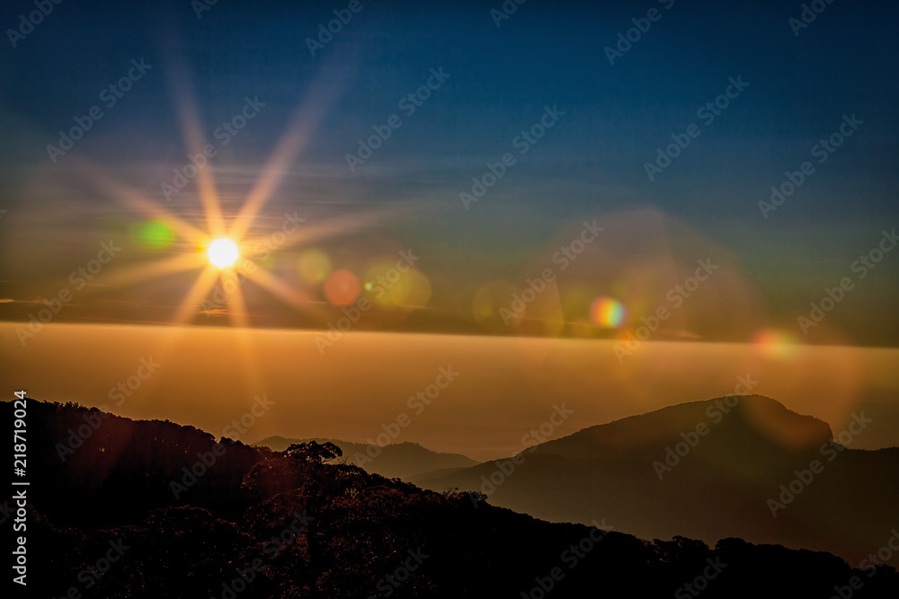 Sun flare  with golden sunrise or sunset sky on the mountains.