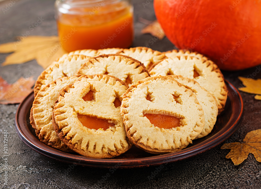 Homemade cookies in the form as Halloween jack-o-lantern pumpkins on the dark table. Homemade cookies in the form as Halloween jack-o-lantern pumpkins on the dark table.
