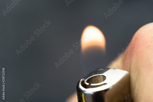 Gasoline lighter, white plastic lighter on a dark background photo