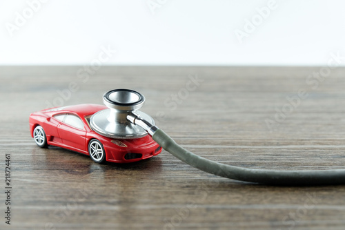 Stethoscope checking up the car on wooden table, Concept of car check up, repair and maintenance..