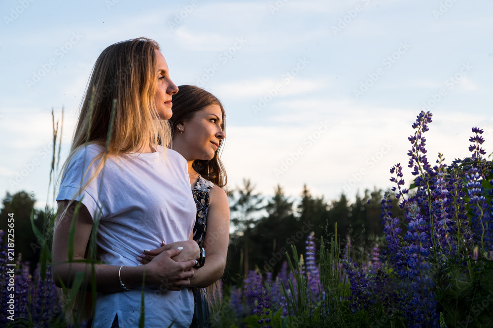 Two female friends in a field of purple lupines Two female friends in a field of purple lupines