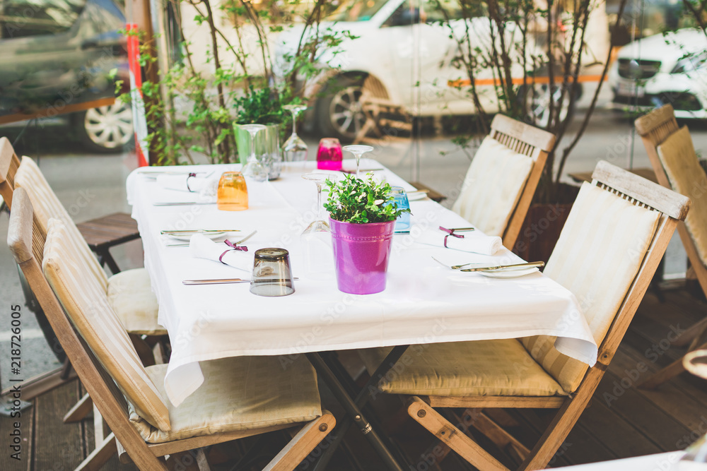 Obraz premium Cafe terrace in small European city. Beautiful terrace or balcony with small table, chair and flowers.