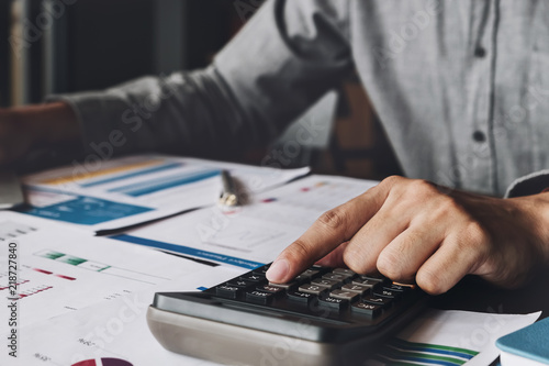 Bookkeeper accounting Concepts; Male use calculator and pen to monitor money saving reports budget to plan before retire. nspector accountant concept.