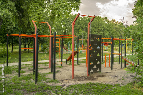Empty sports ground with various training apparatus in the green city park without people