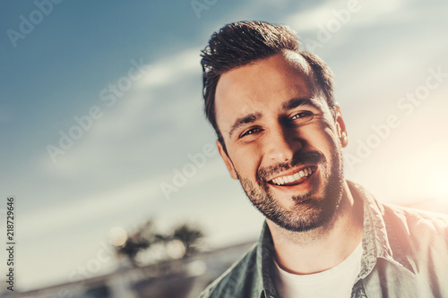 Having fun. Close up portrait of handsome happy guy looking at camera with wide smile
