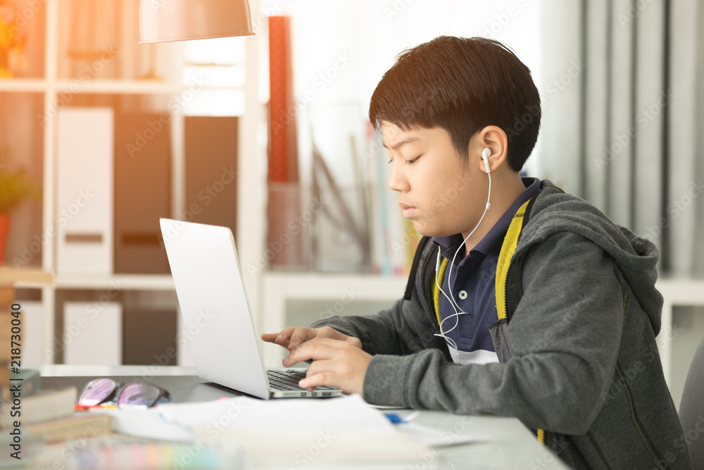 Fototapeta premium Asian cute boy using laptop computer.