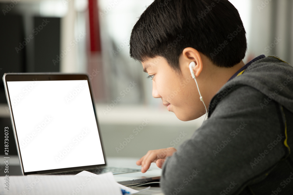 Asian teen boy using laptop computer at home, Asian teen boy using laptop computer at home,