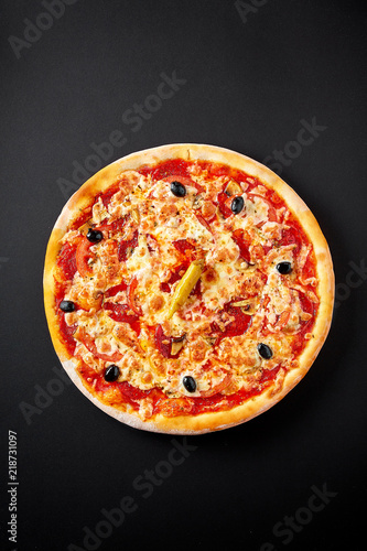 Hot italian pepperoni pizza on black concrete background, top view