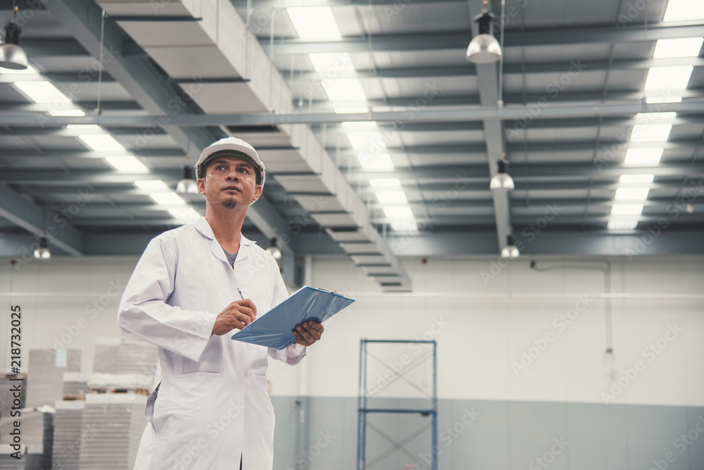 Fototapeta premium Young man white uniform checking stock at store factory
