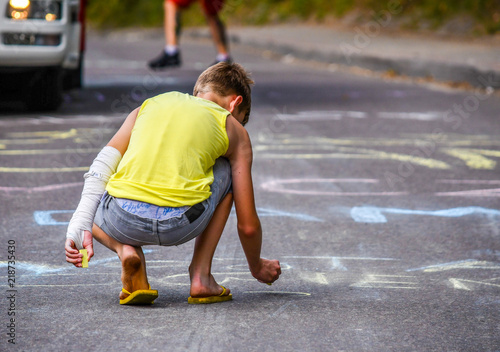 Cuadro en lienzo Kid drawing with chalk on the road