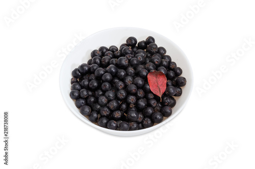 Black chokeberry in white bowl on a white background
