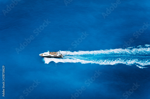 Aerial top view of tourist speed boat sailing in the deep blue sea