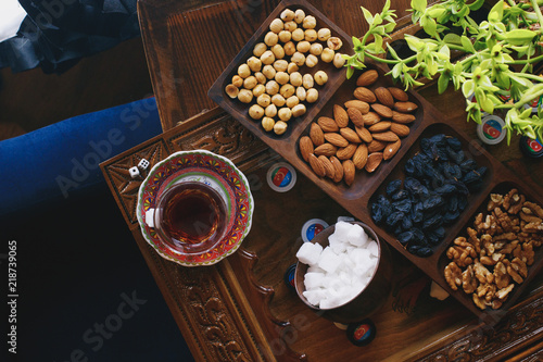Azerbaijani black tea in armudu tea glass with nuts, sugar and dried fruits