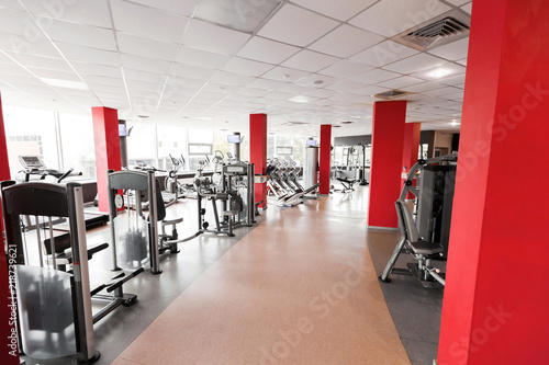 Gym interior with red columns including diversity of modern fitness stations. concept of sport and healthy lifestyle