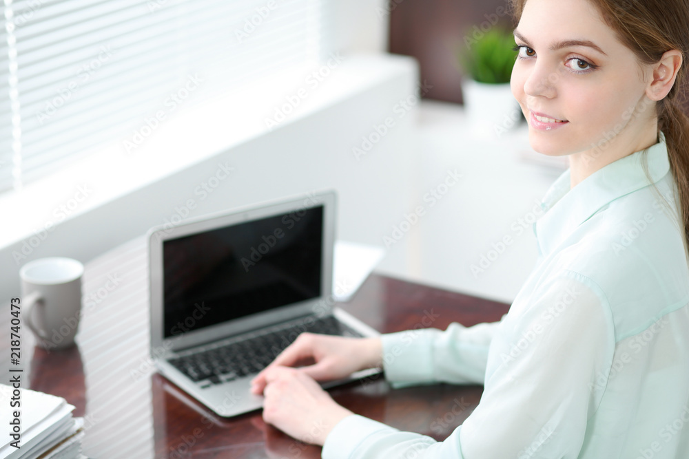 Business woman or secretary sitting at the desk in the office. Green toned image Business woman or secretary sitting at the desk in the office. Green toned image