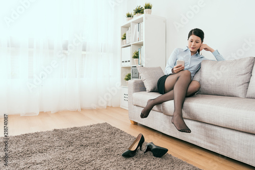 business lady sitting on sofa using smartphone