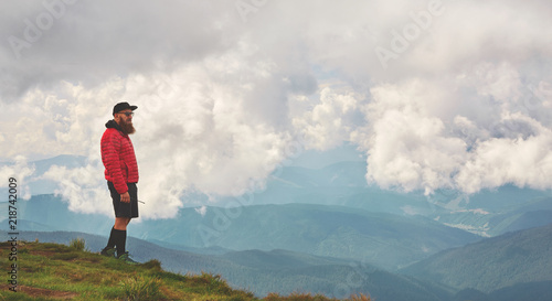 Active male hiker enjoying panoramic view of beautiful cloudy sky in mountains, travel and outdoor adventure concept. Carpathians, Ukraine