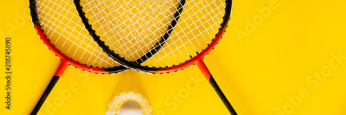 Foto Volant and racket, badminton on yellow background
