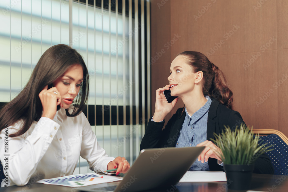 Women looking financial documents in laptop at table Women looking financial documents in laptop at table