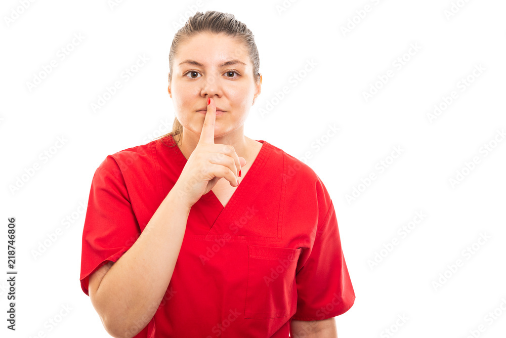 Young medical nurse wearing red scrub showing silent gesture.