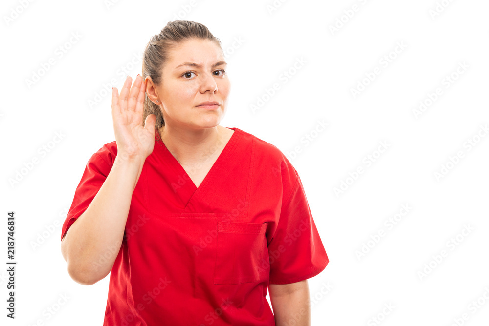 Young medical nurse wearing red scrub showing can't hear gesture. Young medical nurse wearing red scrub showing can't hear gesture.