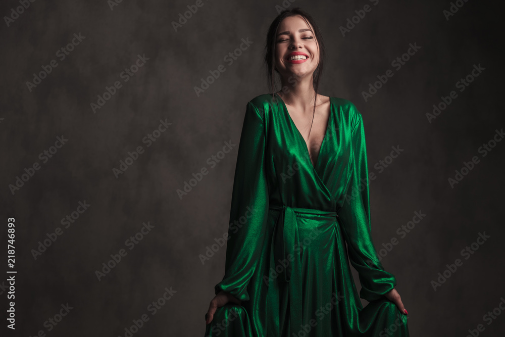 portrait of beautiful woman wearing a green gown laughing