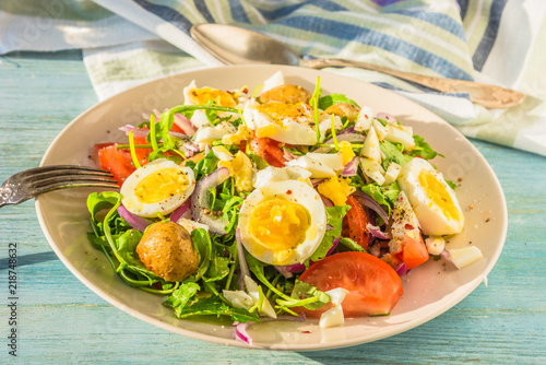 German food - vegetable salad with boiled egg on plate on rustic background