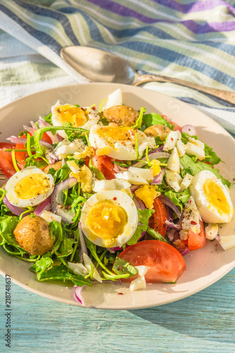 Mediterranean salad with tomatoes, arugula, potatoes and boiled eggs