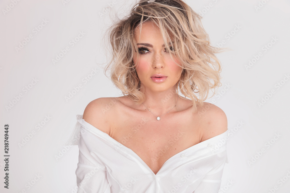 blonde woman wearing makeup and bouffant shirt looks to side blonde woman wearing makeup and bouffant shirt looks to side