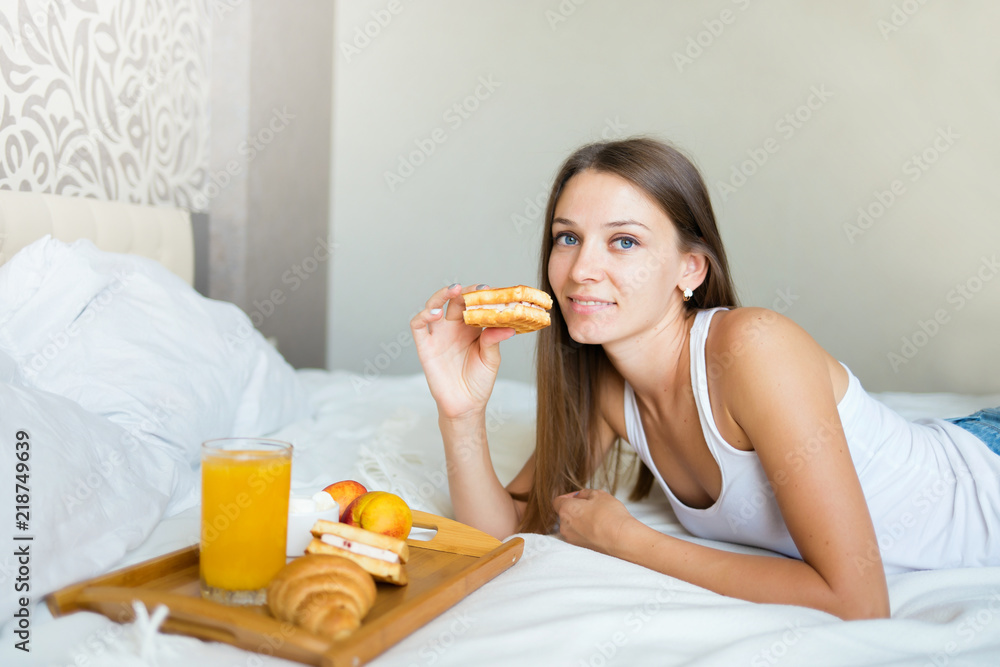 beautiful brunette girl eating a healthy breakfast in bed beautiful brunette girl eating a healthy breakfast in bed