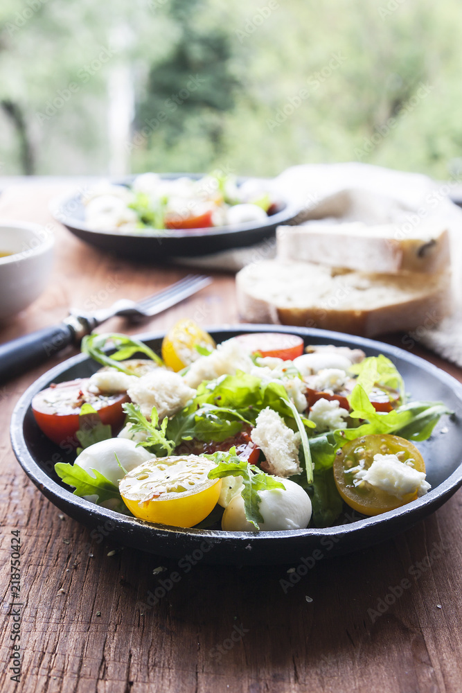 Fresh summer salad with mixed colour cherry tomatoes, lettuce, arugula and mozzarella cheese