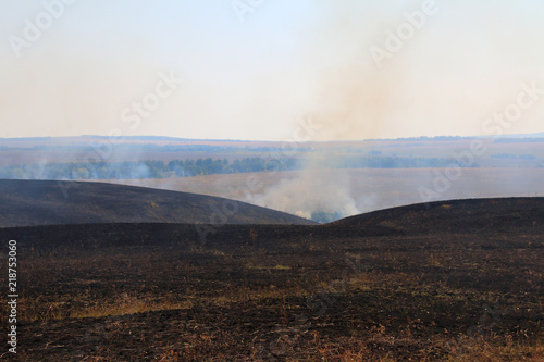 Burnt out smoking steppe after disastrous fire