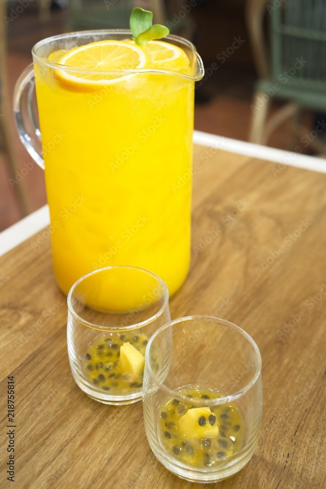 big glass jar with orange and passion fruit juice on a wooden background, space for text. colorful drinks. Natural fruit ingredients for drinks big glass jar with orange and passion fruit juice on a wooden background, space for text. colorful drinks. Natural fruit ingredients for drinks