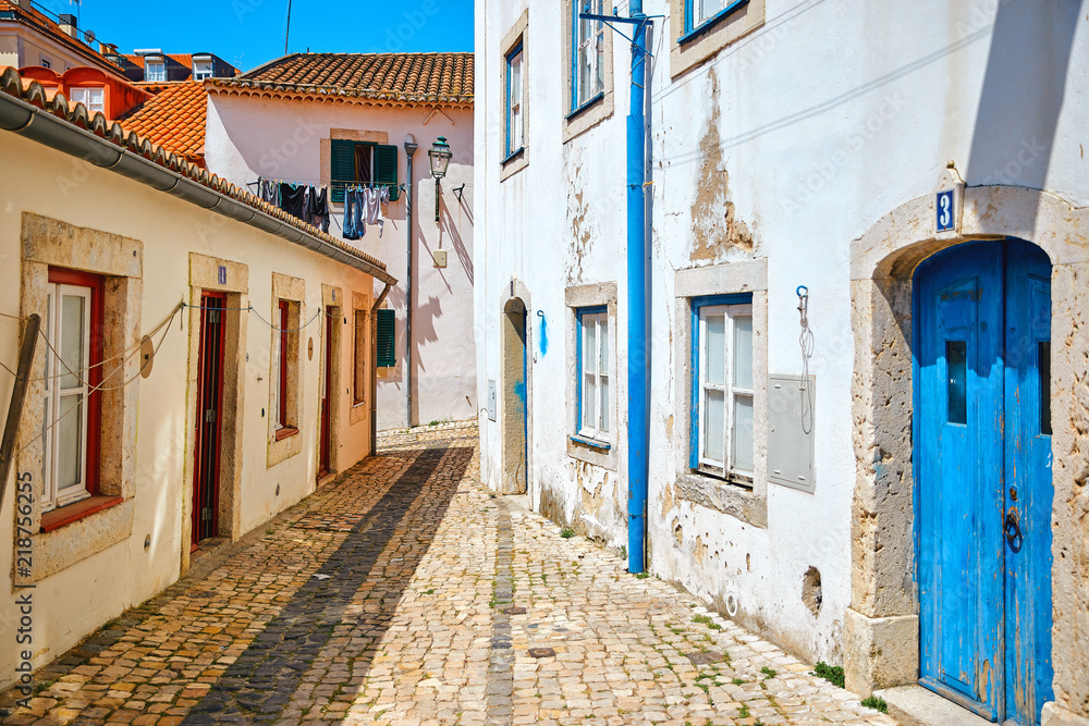 Fototapeta premium Ancient street of Lisbon old town in Alfama district. Vintage
