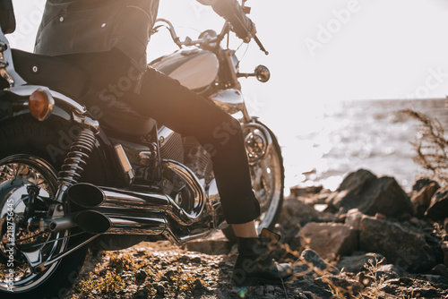 low section view of biker sitting on classical motorbike outdoors