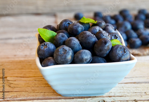 Freshly picked blueberries in a bowl on old wooden background.Fresh organic blueberry.
Bilberries.Selective focus.
