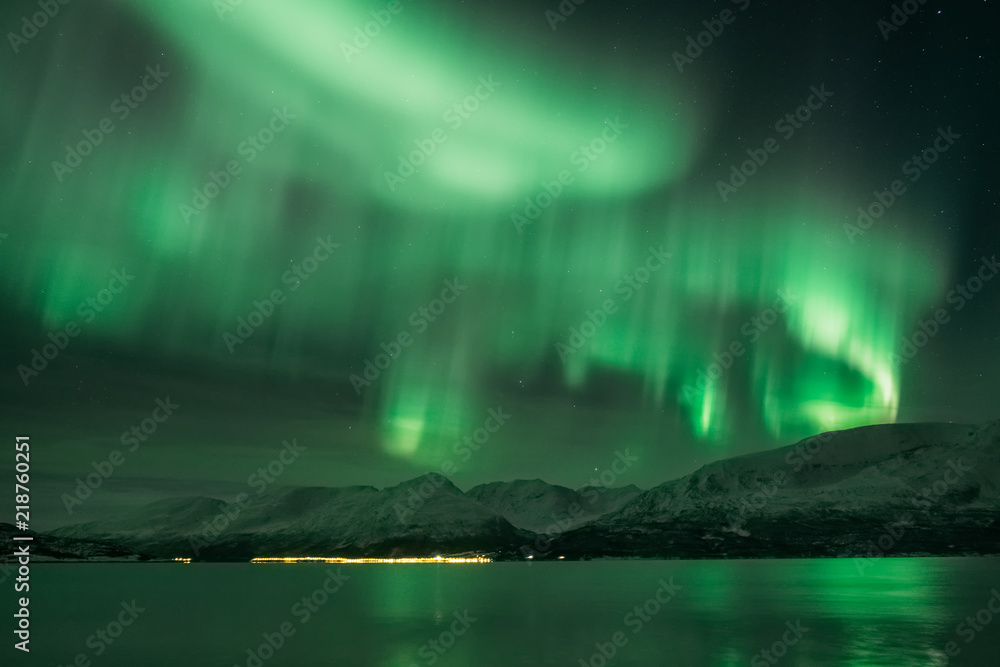 Landscape of aurora borealis over the Norway fjord in winter.