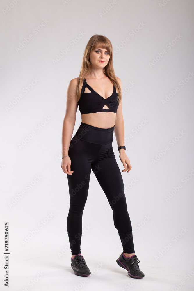 Sport woman in sport style clothes. Attractive and sportive woman in black  leggings and black top. Isolated on white background Stock Photo | Adobe  Stock