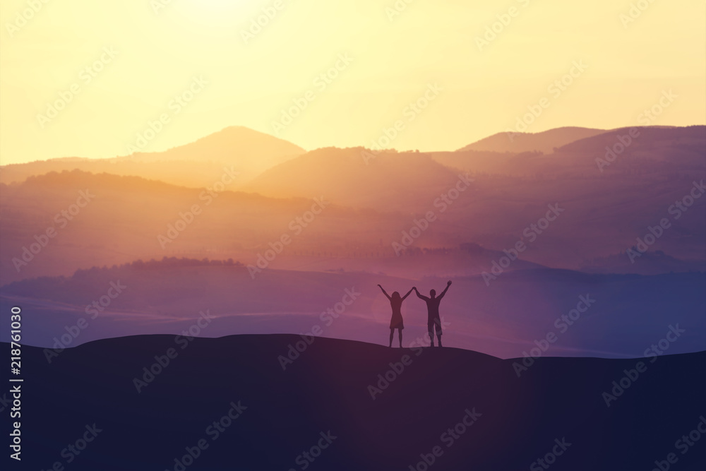 Happy man and woman standing on a hill