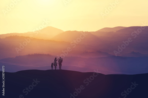 Family with two children standing on a hill