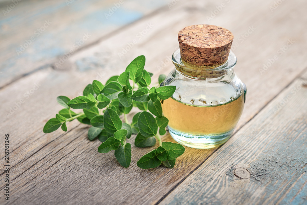 Obraz premium Essential oil of oregano in vintage bottle
