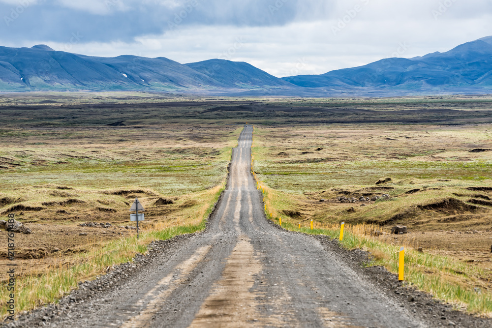 Dirt road in north east Iceland highlands highway 864 to Dettifoss with barren bare brown landscape, car and moss, grass on rocks, overcast cloudy day, volcanic landscape Dirt road in north east Iceland highlands highway 864 to Dettifoss with barren bare brown landscape, car and moss, grass on rocks, overcast cloudy day, volcanic landscape