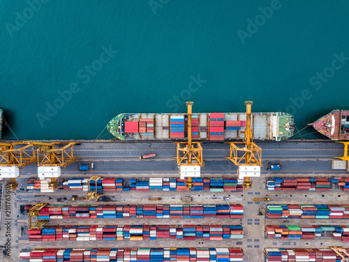 Top view of international port with Crane loading containers in import export business logistics.