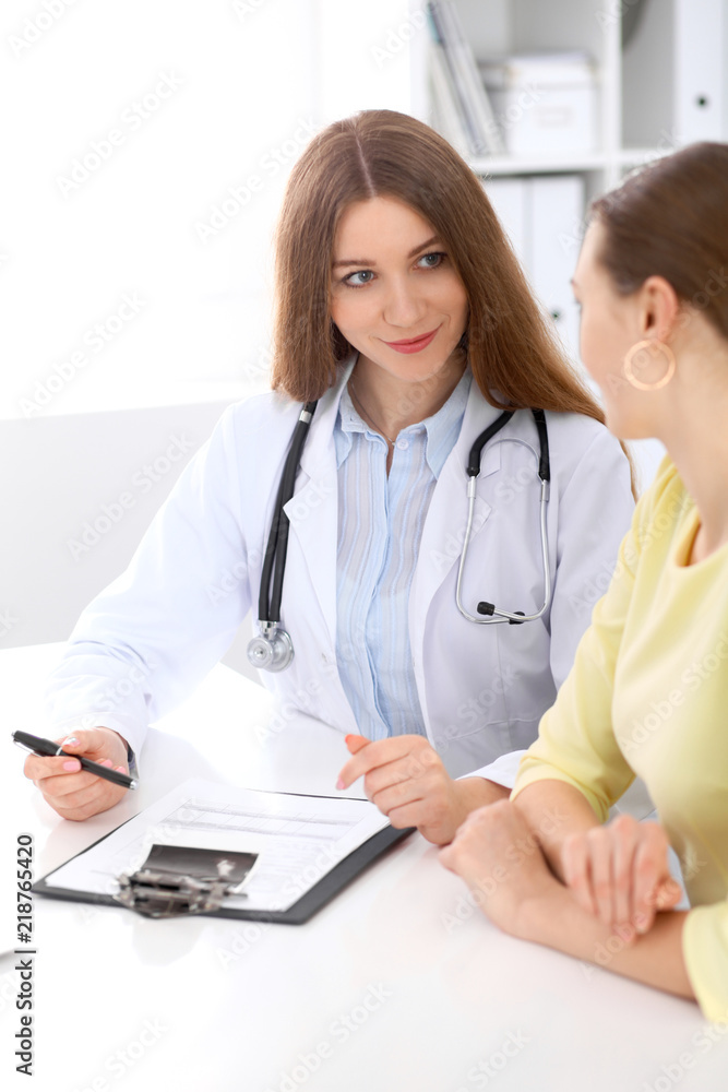 Doctor and patient sitting at the desk near window Doctor and patient sitting at the desk near window