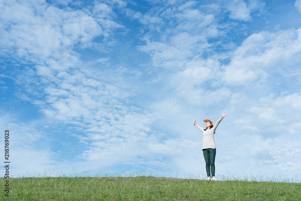 Standing woman raised her hands on the mountain, natural green and beautiful sky. Standing woman raised her hands on the mountain, natural green and beautiful sky.