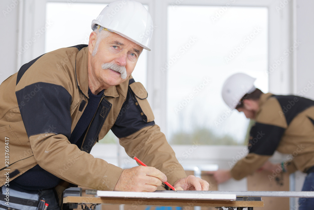 senior carpenter measures wooden plank senior carpenter measures wooden plank