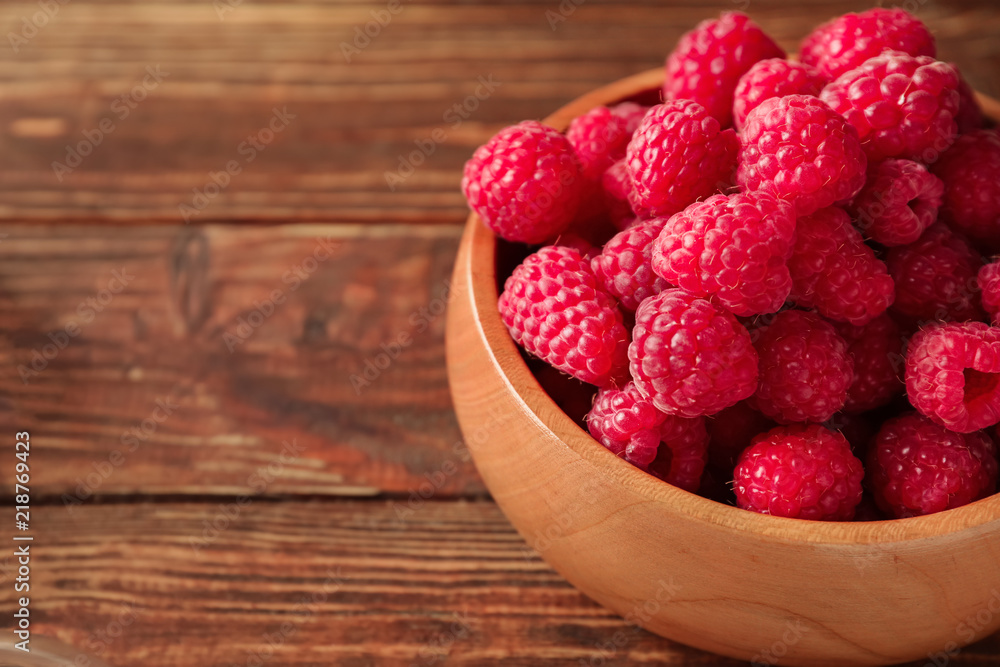 Bowl with fresh ripe raspberries on wooden table, closeup Bowl with fresh ripe raspberries on wooden table, closeup