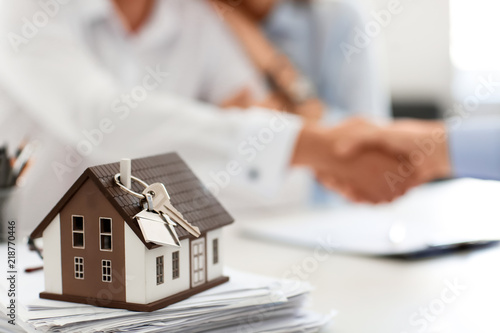 House model with key on table in office of real estate