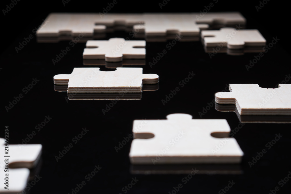 Incomplete wooden puzzles on brown wooden desk. Incomplete wooden puzzles on brown wooden desk.